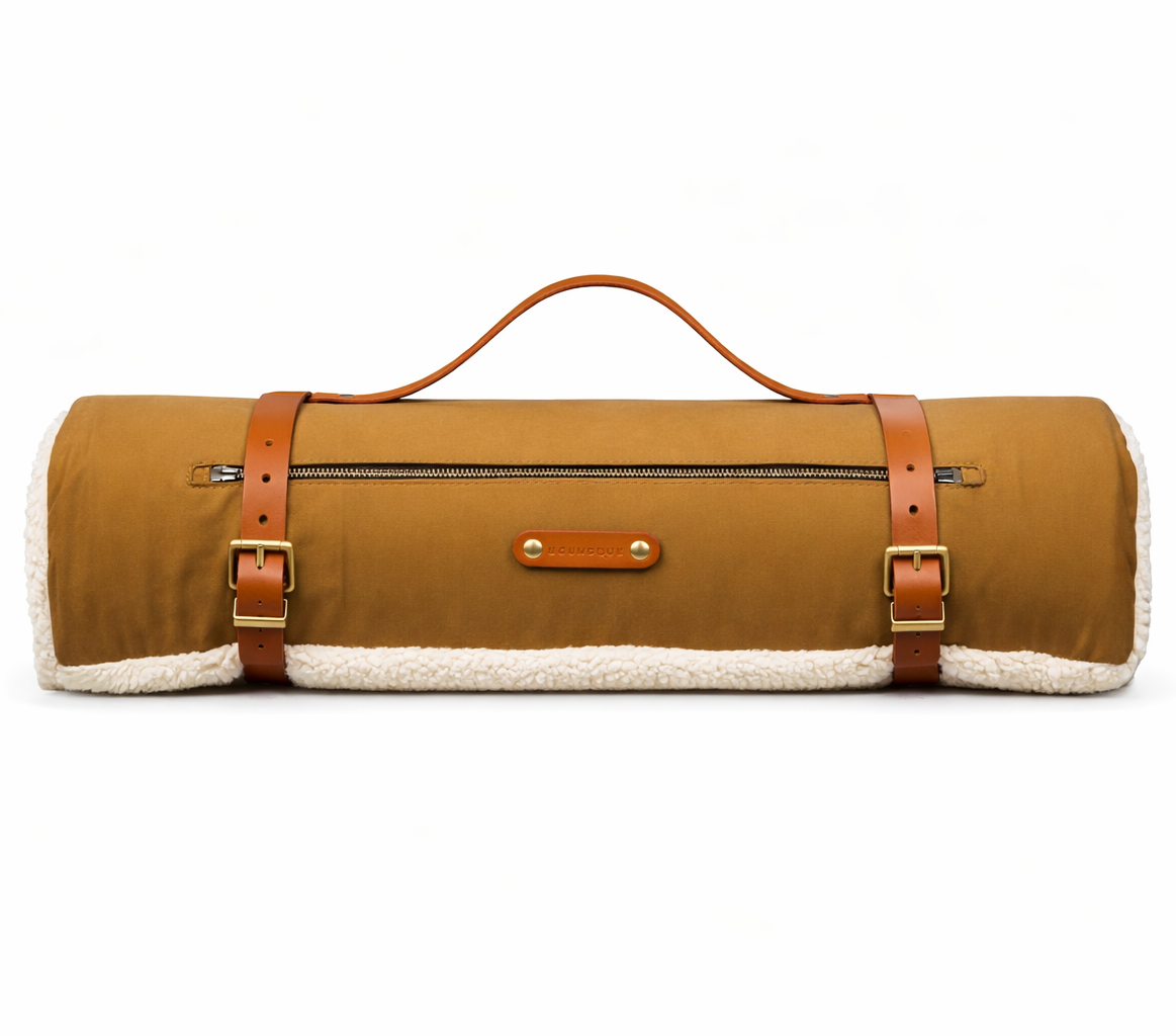 Brown roll-up dog bedwith leather straps on a white background