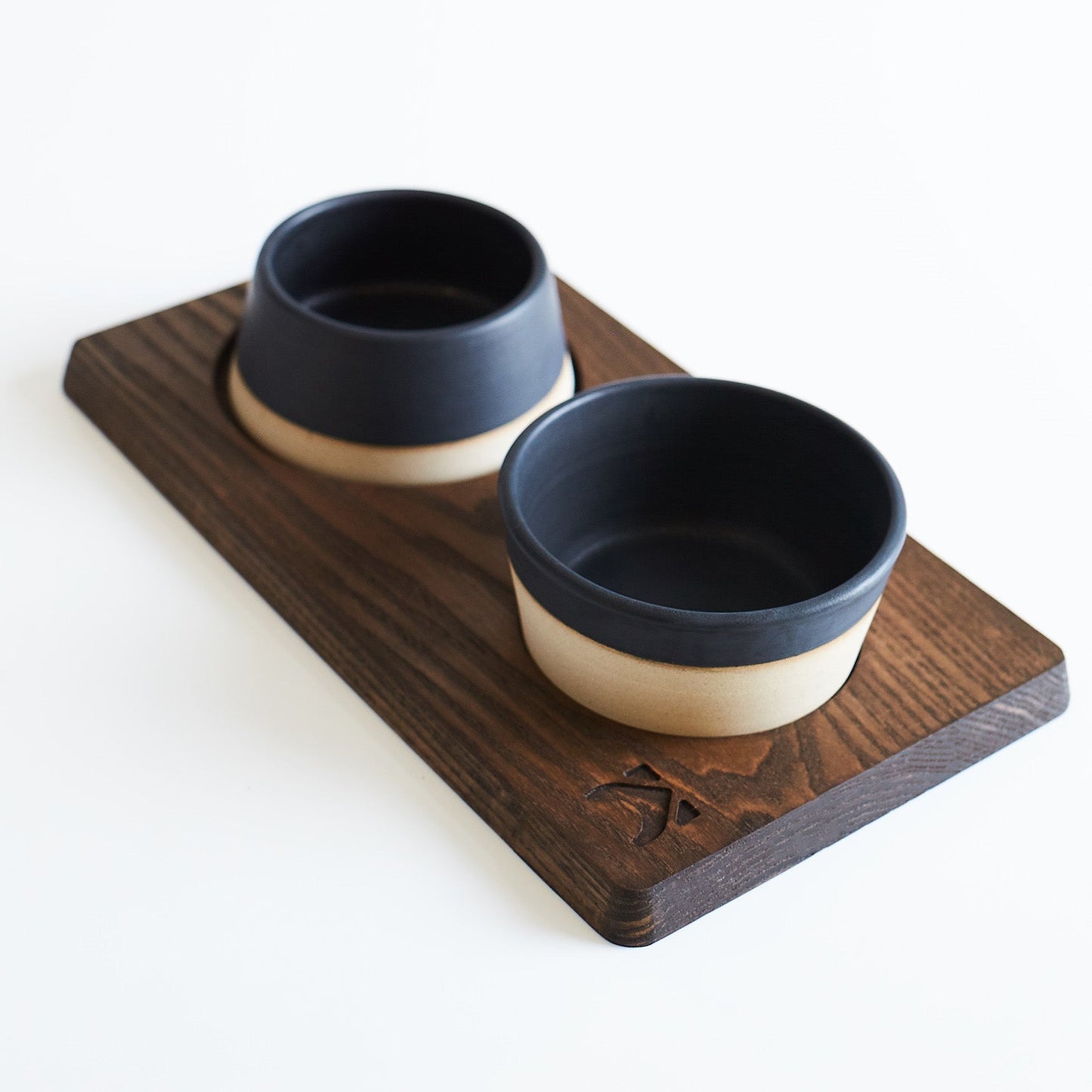 Two ceramic bowls on a wooden tray