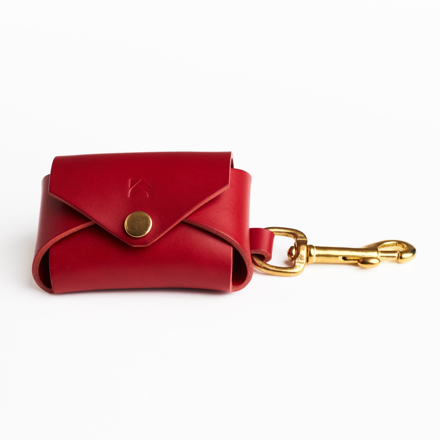 Poppy Red leather poop bag holder with solid brass eyelet dispenser and clip on a white background