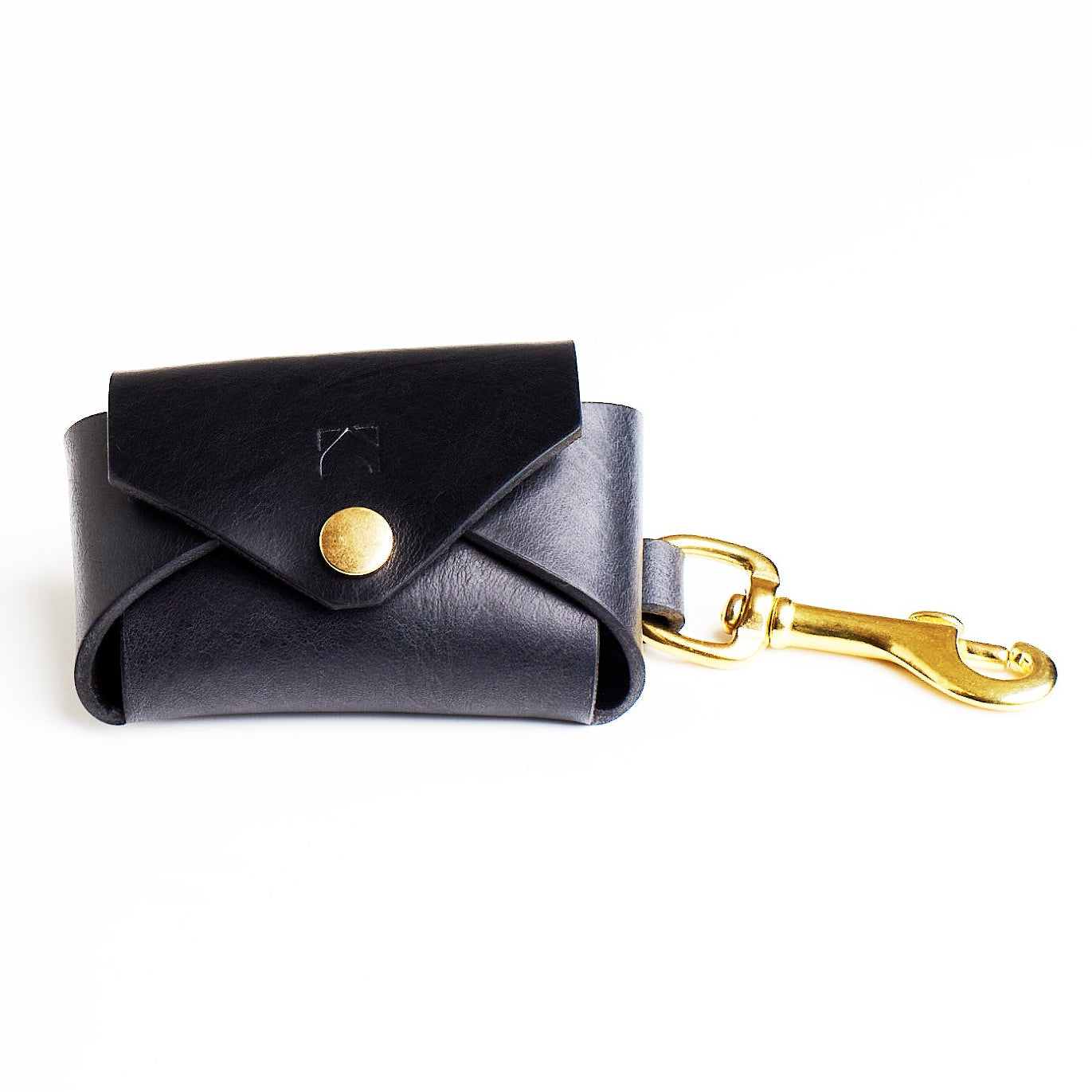 black leather poop bag holder with brass hardware on a white background